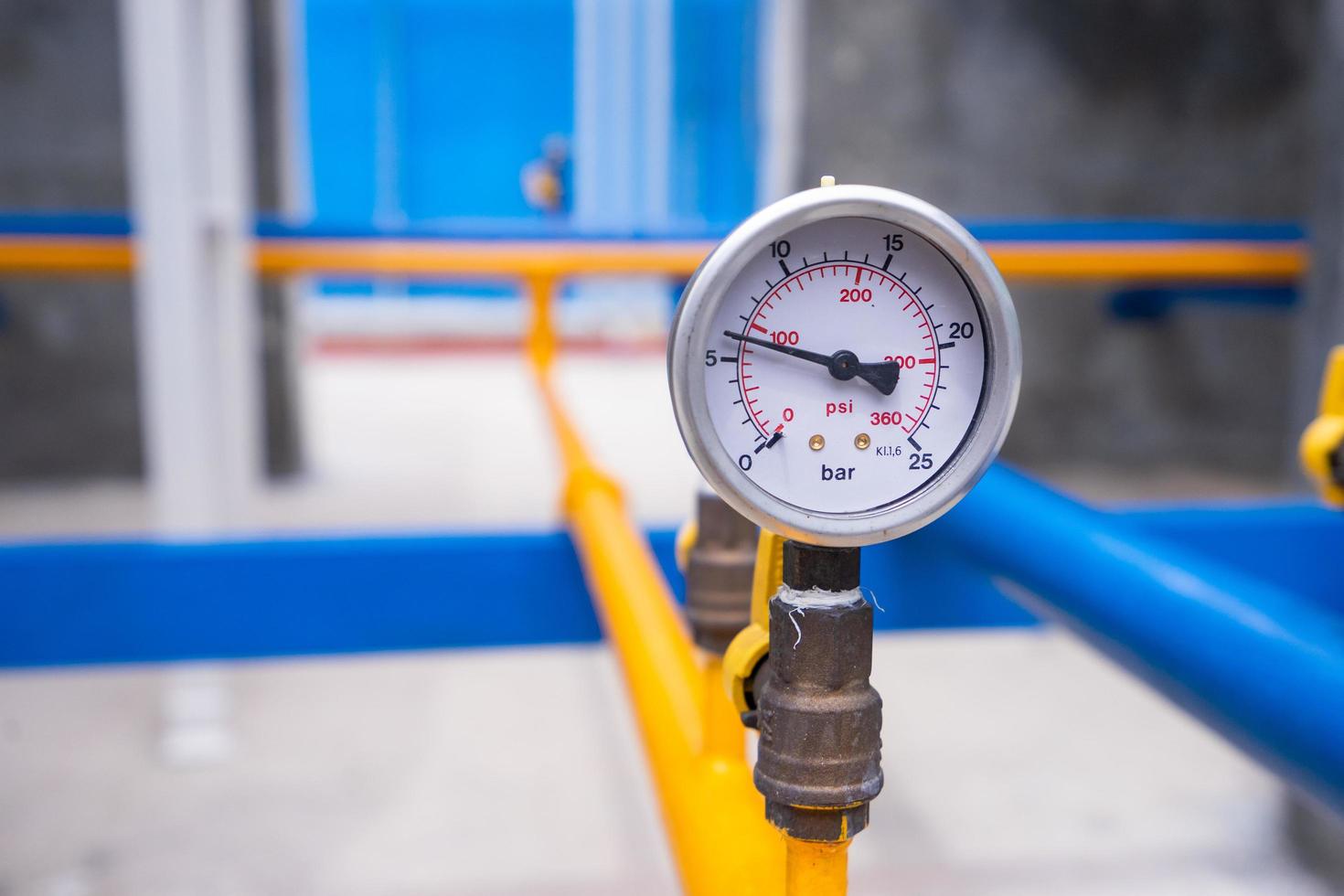 Primer plano de un manómetro para medir la presión del gas. tuberías y válvulas en planta industrial foto