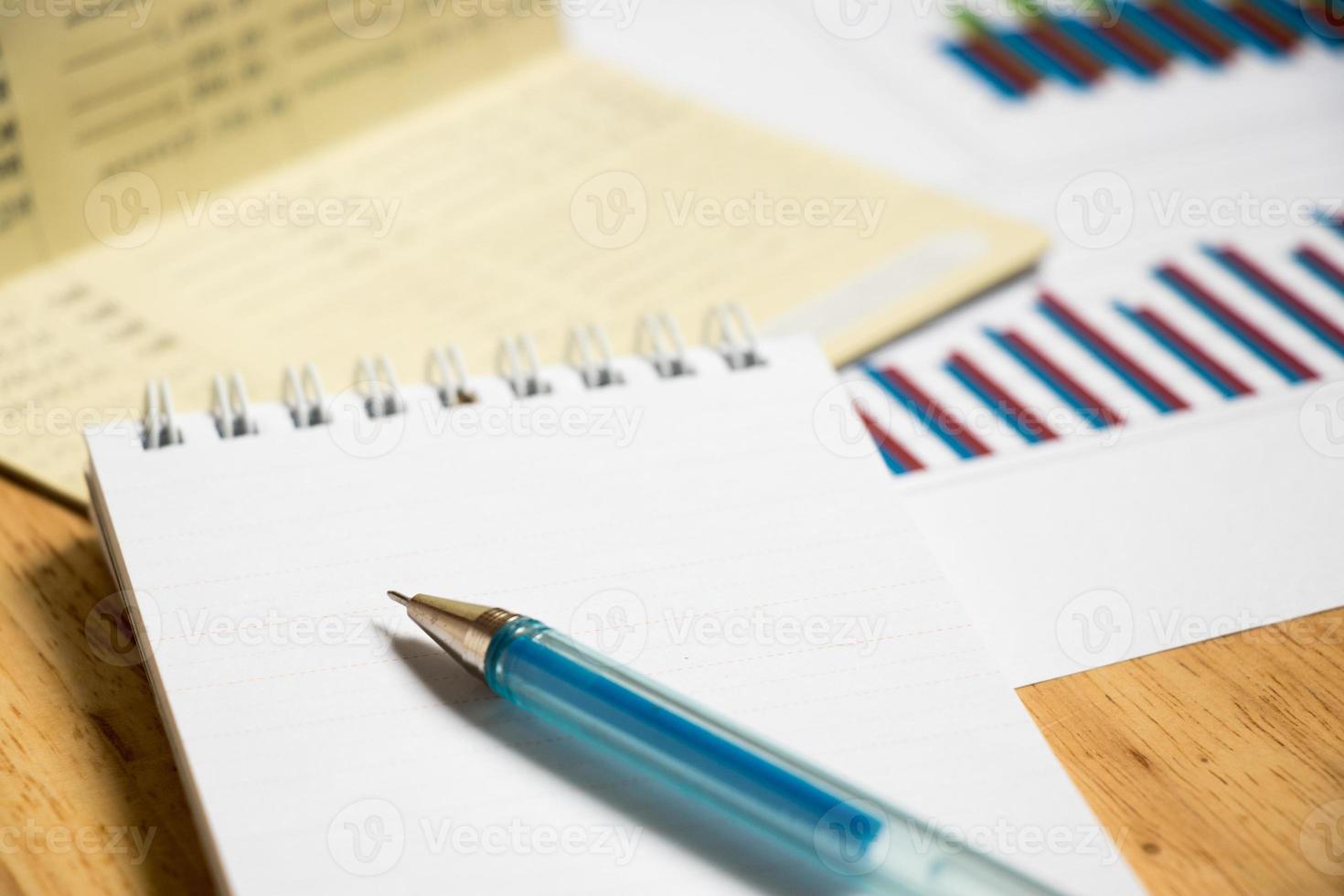 Fondo de libreta, cuaderno con bolígrafo y gráfico financiero. foto