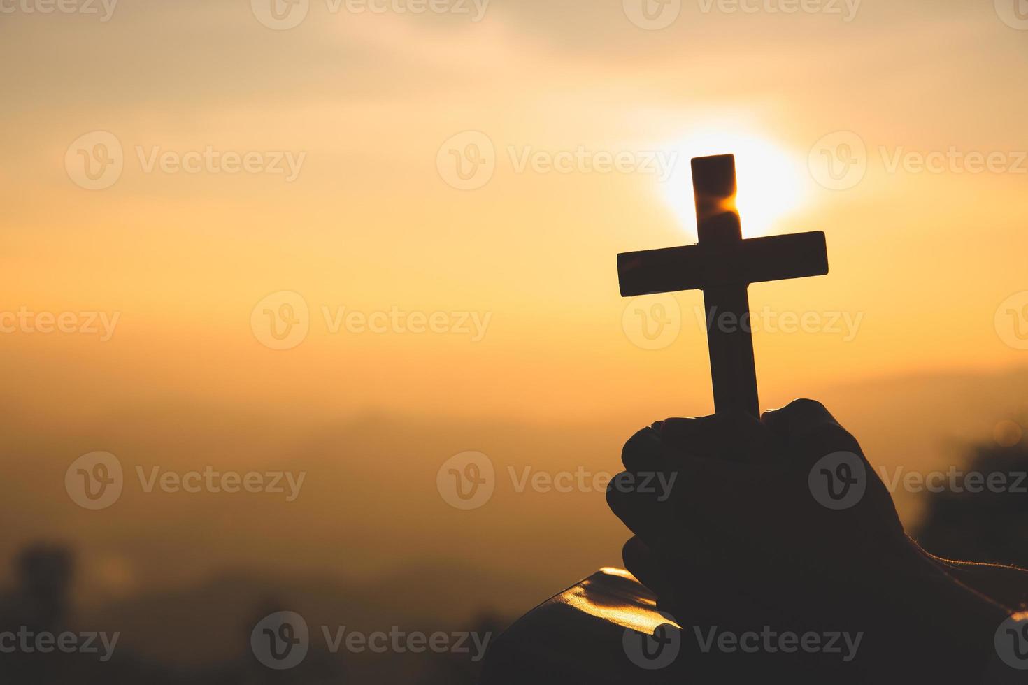 Hands of a Christian woman holding a cross while praying to God.Religious beliefs, Copy space. photo