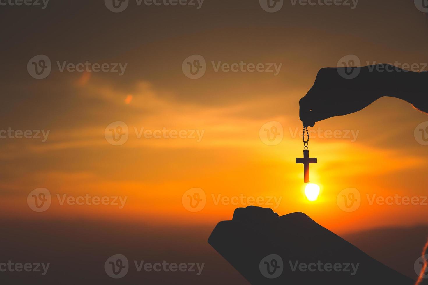 Women standing holding holy  bible and the crucifix for worshipping God at sunset background, Pray to the god, christian silhouette concept. photo