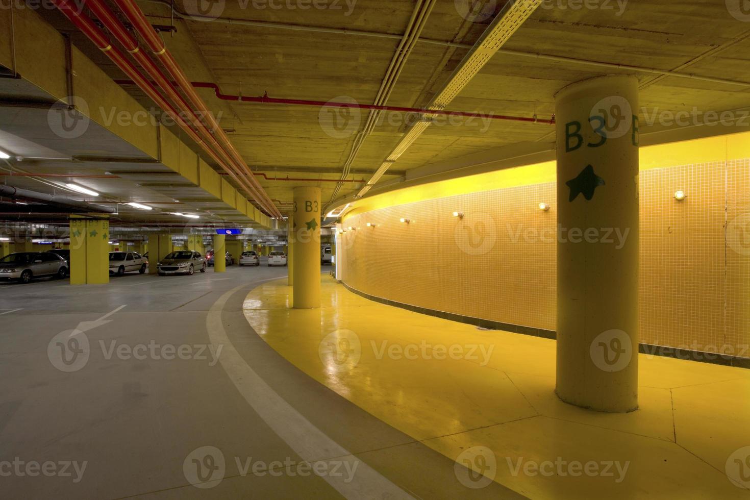 Iluminación y señalización luminosa en un aparcamiento subterráneo de un centro comercial, España foto
