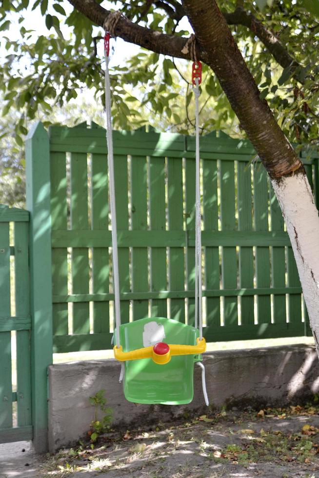 Fotografía sobre tema columpio de bebé vacío colgando del cerezo foto