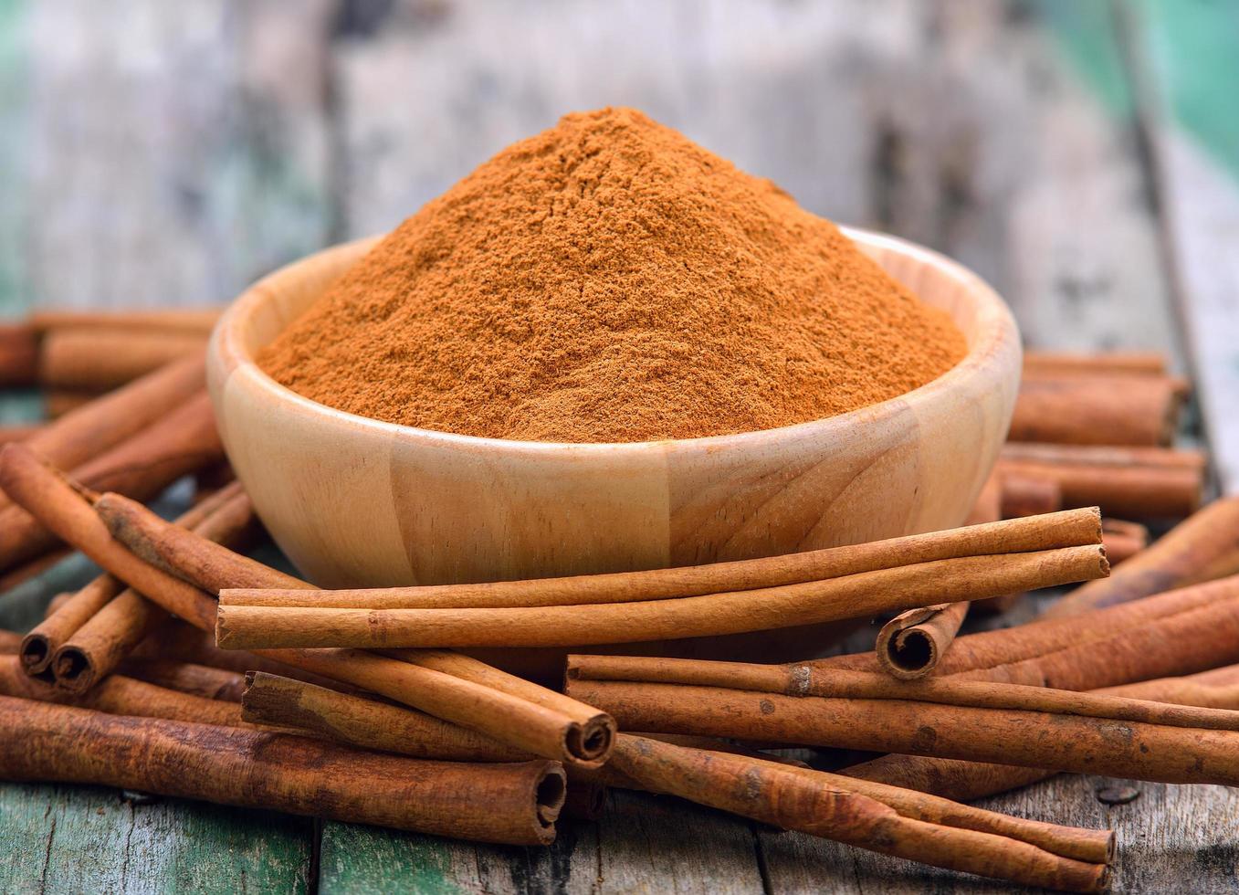 Cinnamon sticks and powder cinnamon in the bowl on table photo