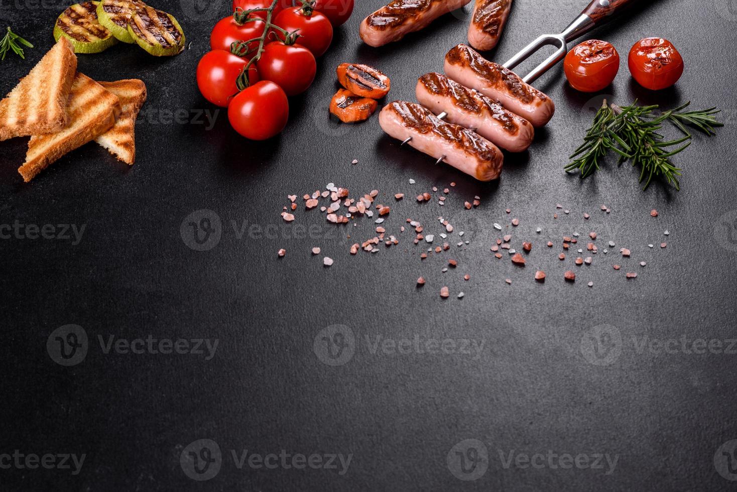 Tasty, fresh sausages grilled with vegetables spices and herbs photo