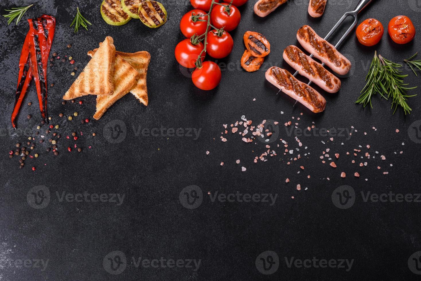 Tasty, fresh sausages grilled with vegetables spices and herbs photo