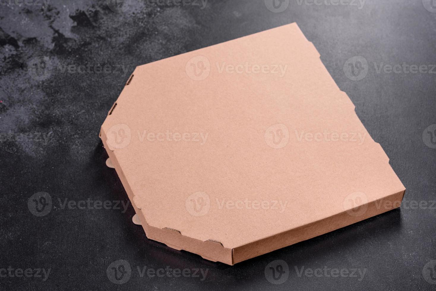 Caja de cartón marrón de forma cuadrada para transporte y entrega de pizza. foto