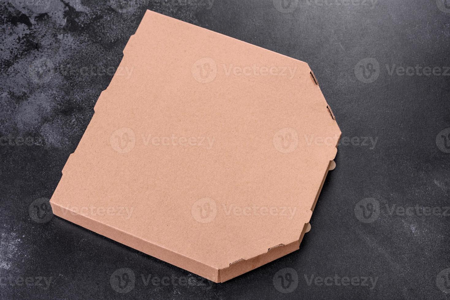Caja de cartón marrón de forma cuadrada para transporte y entrega de pizza. foto