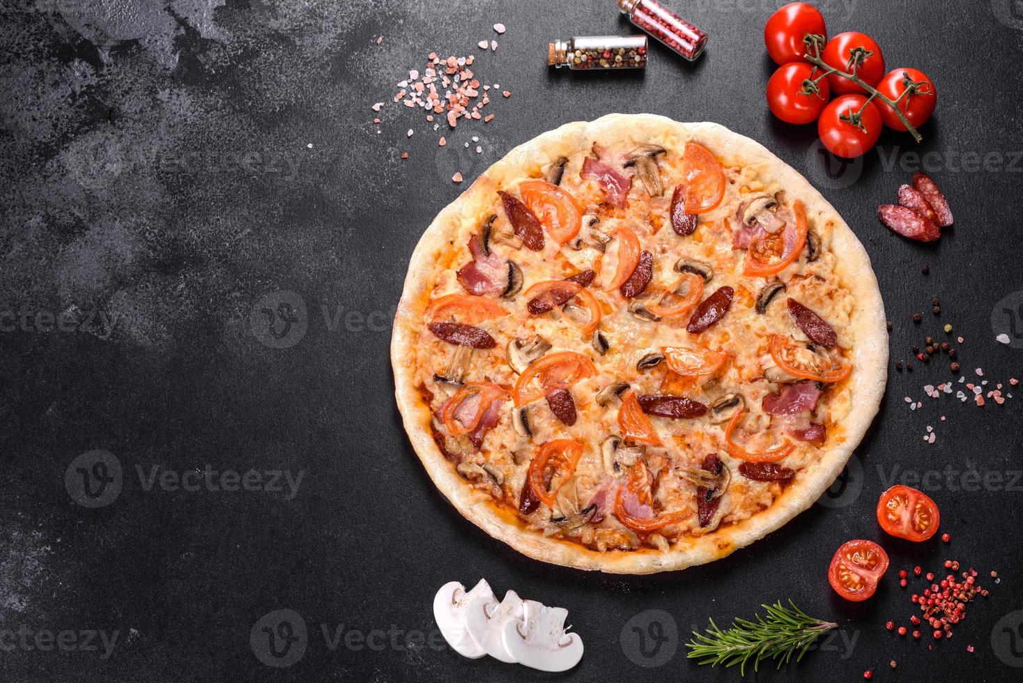 deliciosa pizza fresca hecha en un horno de hogar con tomates, salchichas y champiñones foto