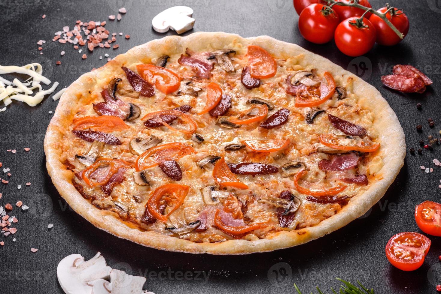 deliciosa pizza fresca hecha en un horno de hogar con tomates, salchichas y champiñones foto