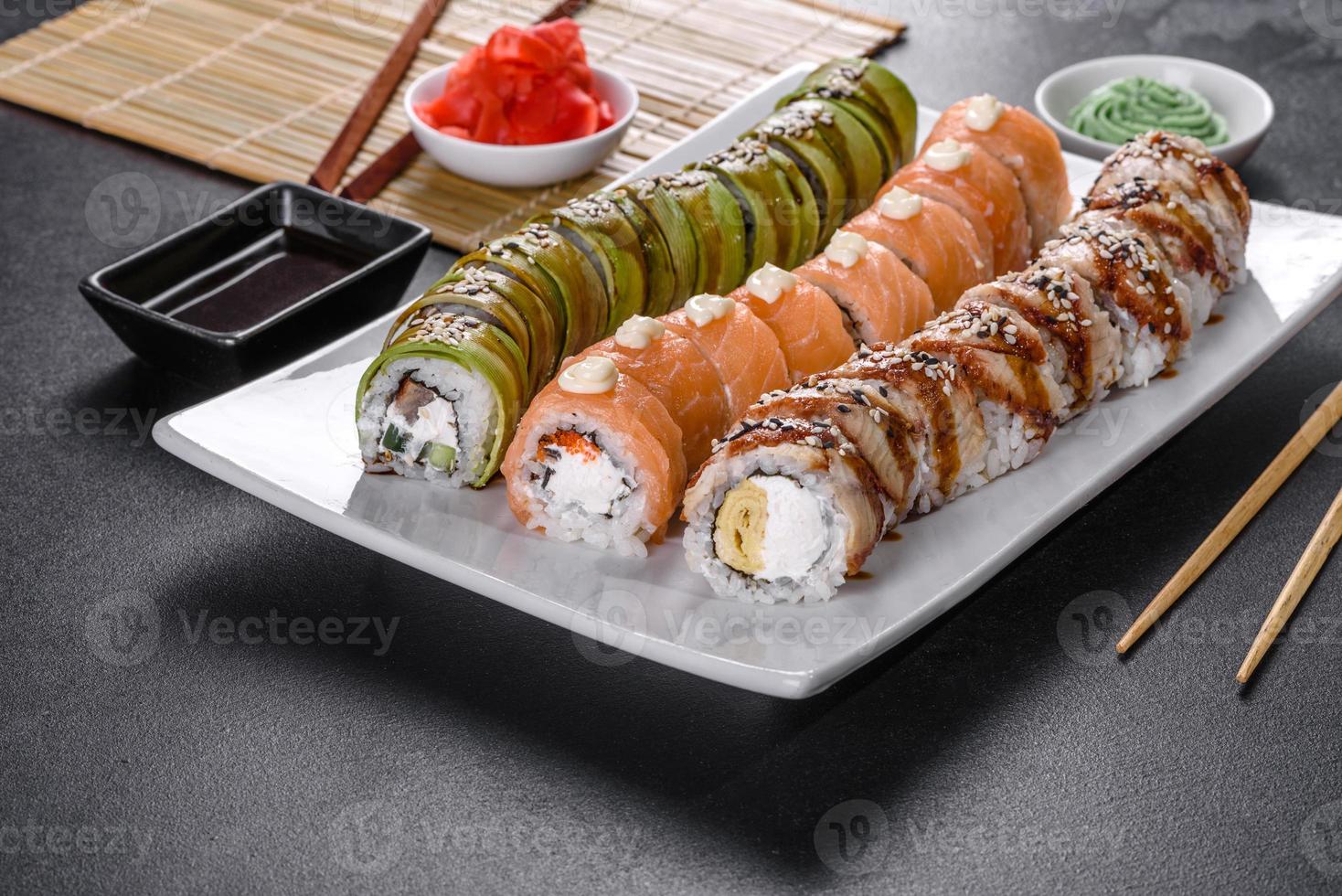 Rollos de sushi frescos y sabrosos dispuestos en forma de dragón con jengibre y wasabi foto