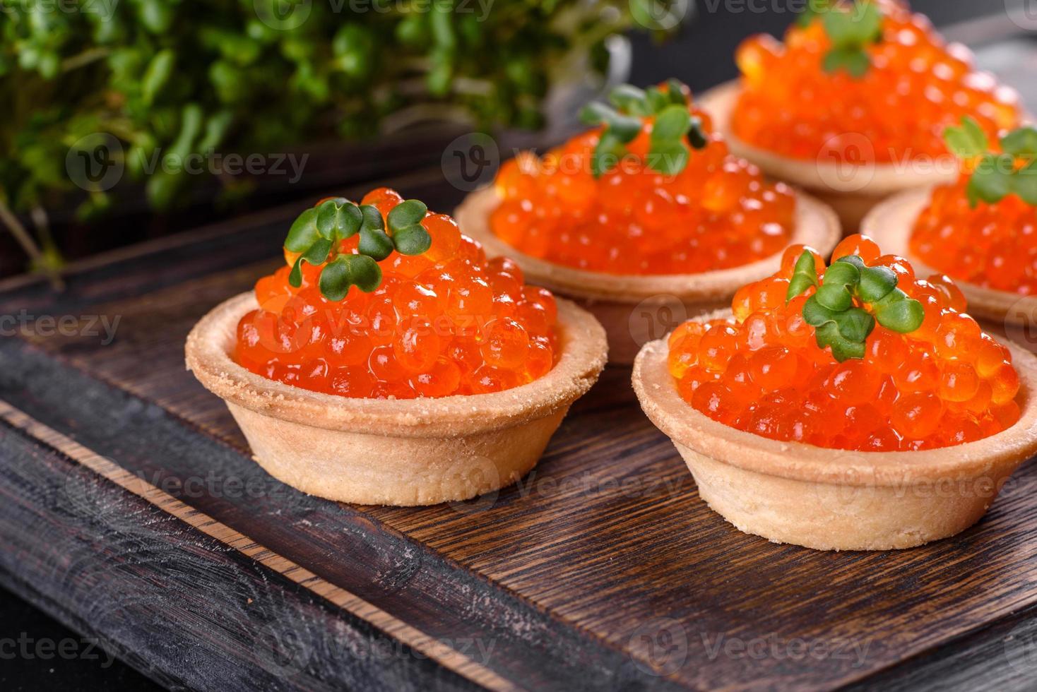 Delicious fresh red caviar on a dark concrete table photo