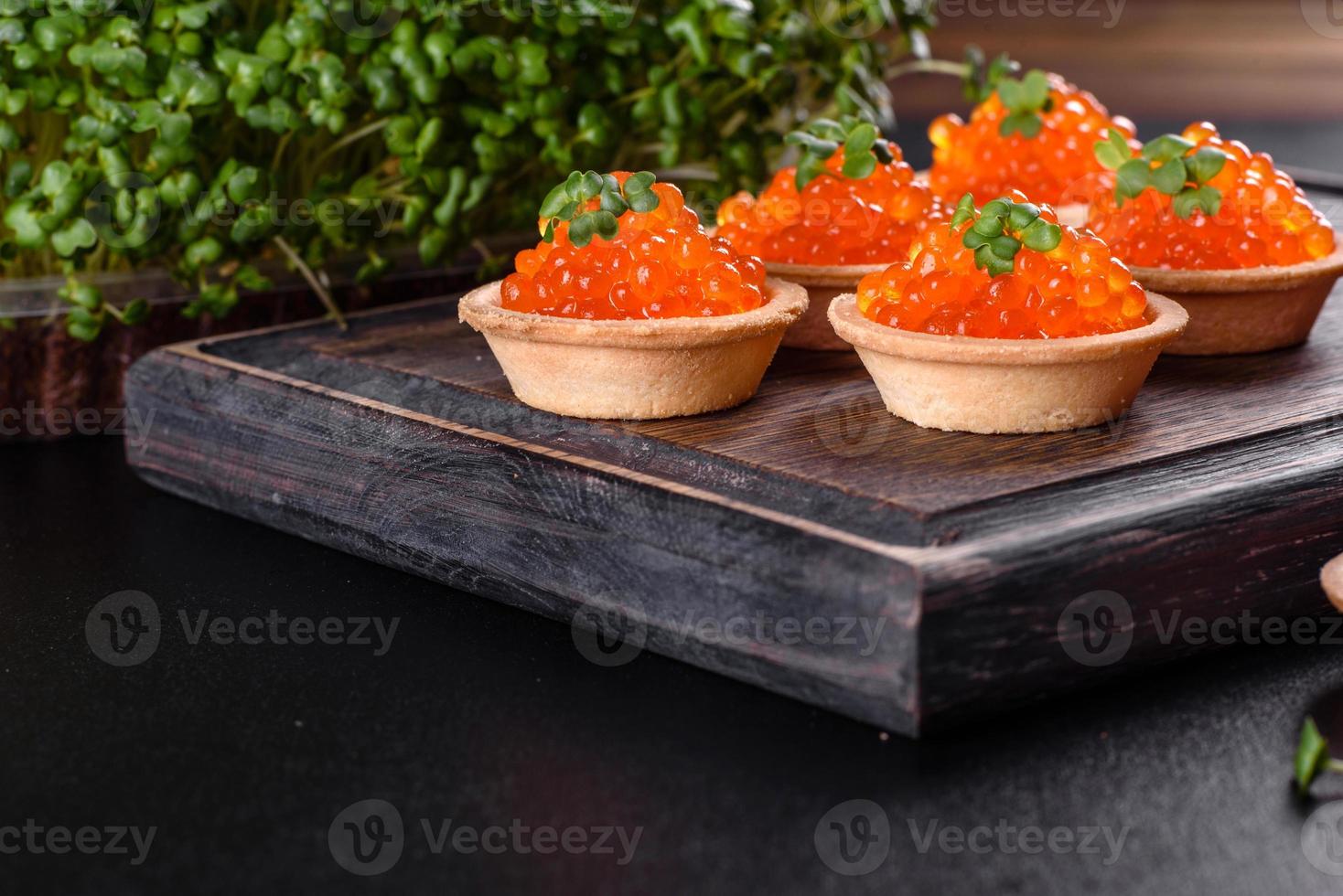 Delicious fresh red caviar on a dark concrete table photo