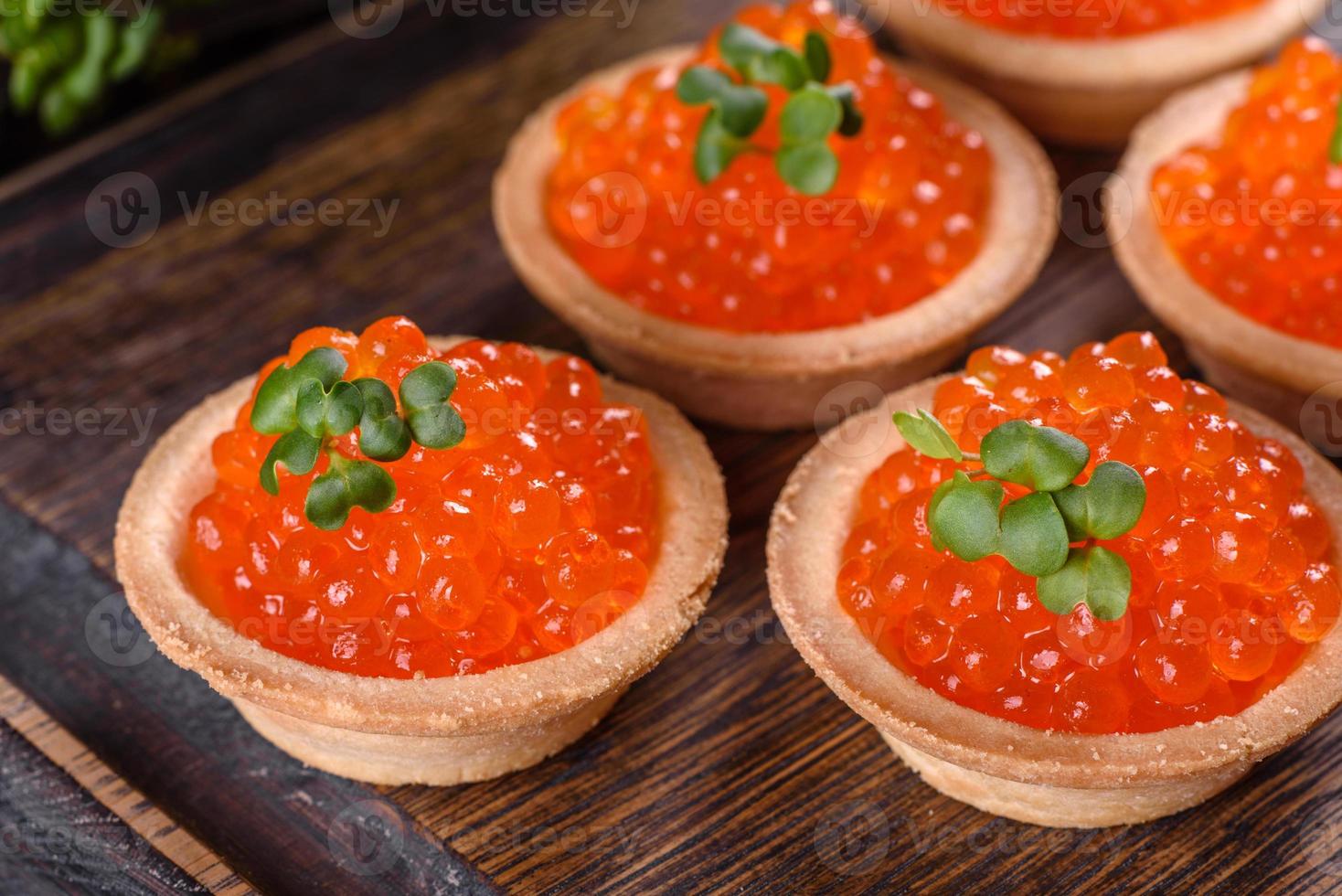 Delicioso caviar rojo fresco sobre una mesa de hormigón oscuro foto