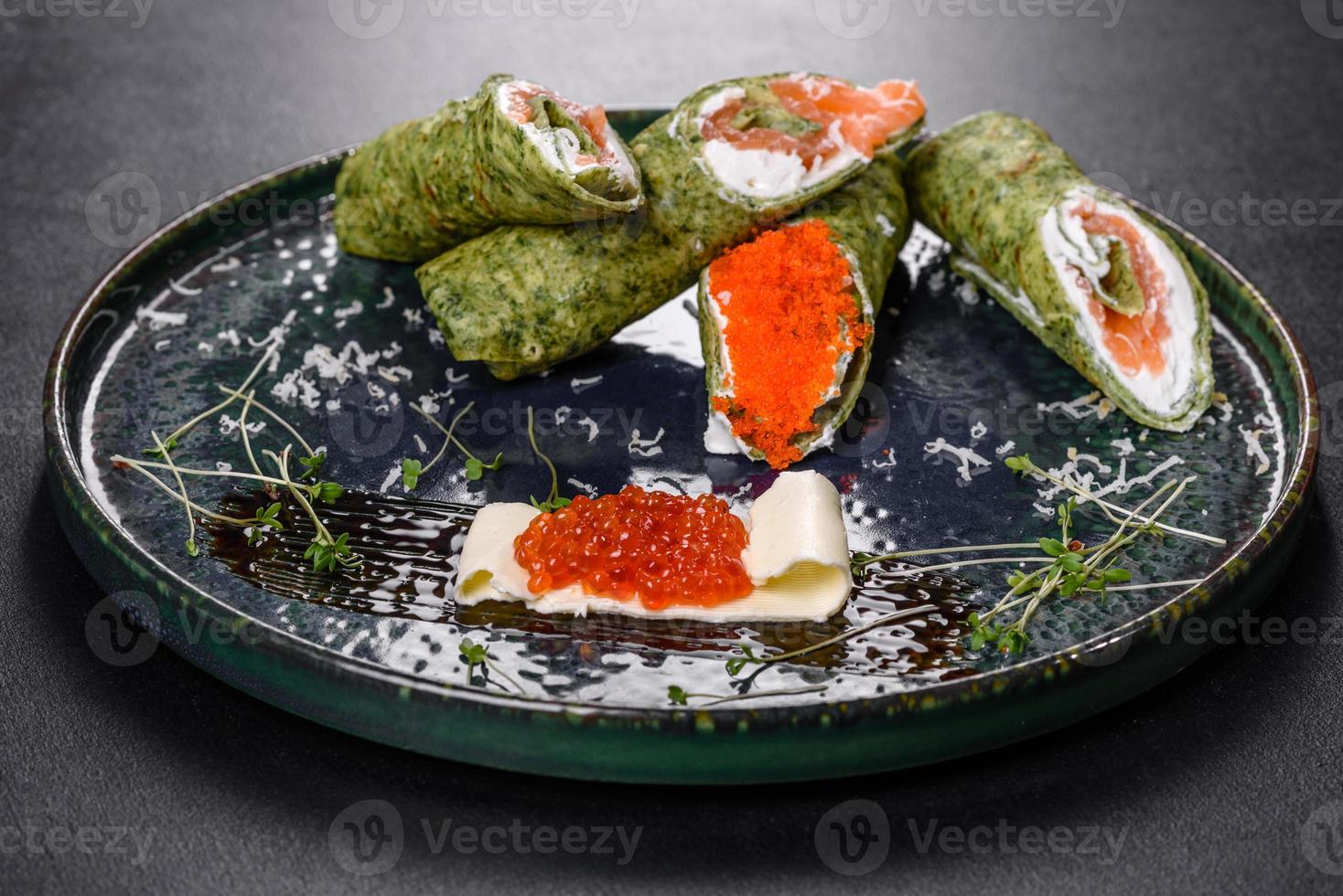 Delicious fresh sweet pancakes on a plate with red fish and caviar photo
