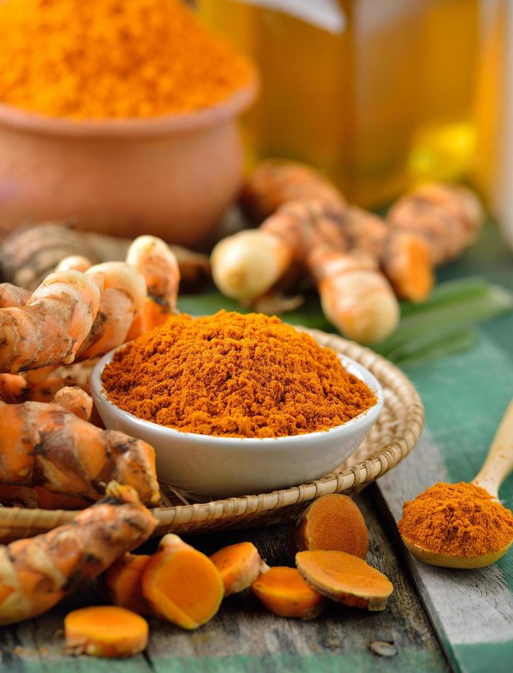 Turmeric roots in the basket on wooden table photo