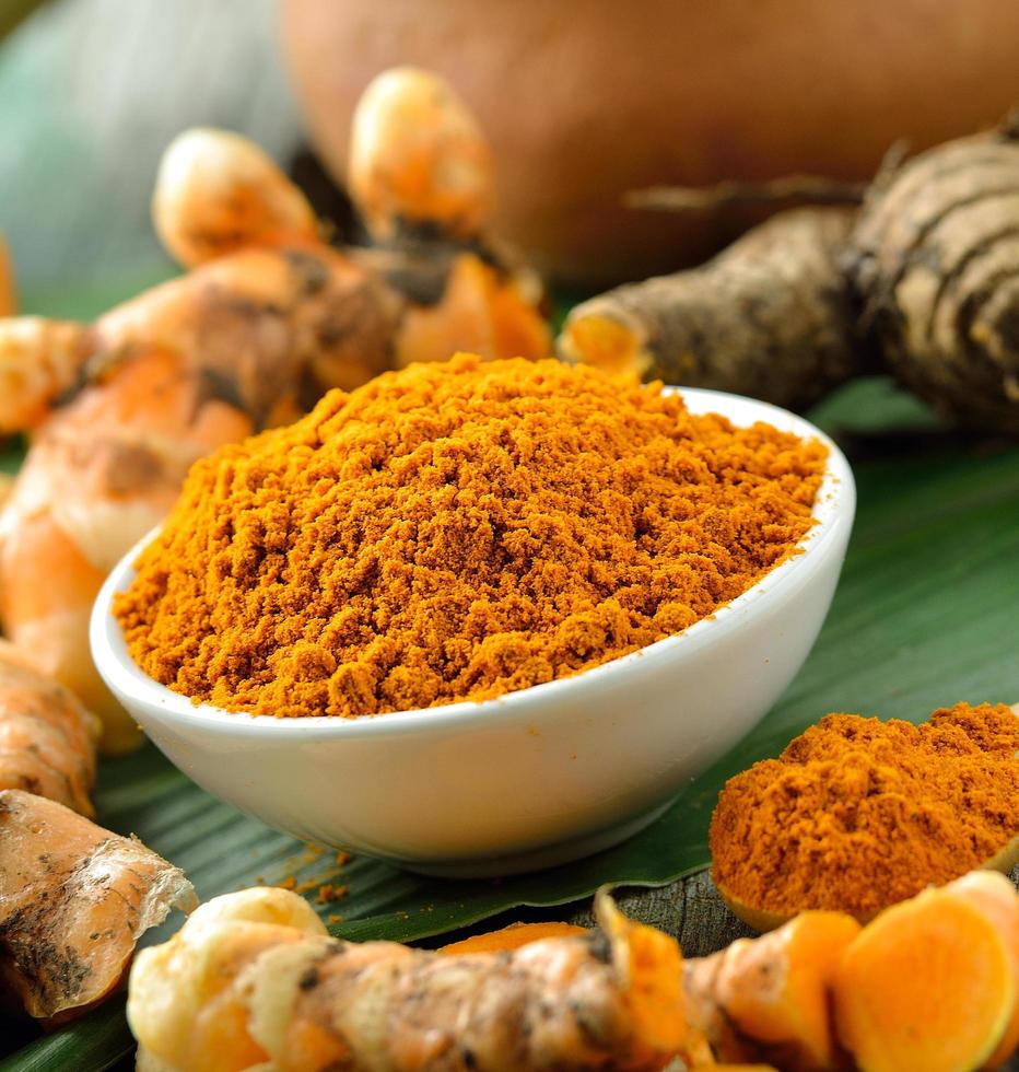 Turmeric roots in the basket on wooden table photo