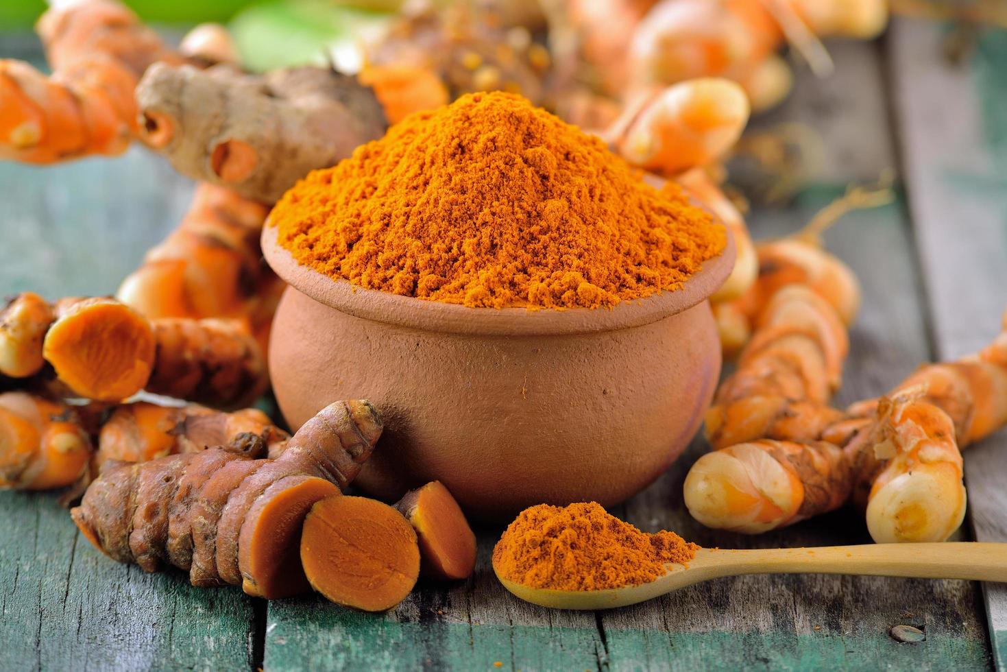 Turmeric roots in the basket on wooden table photo