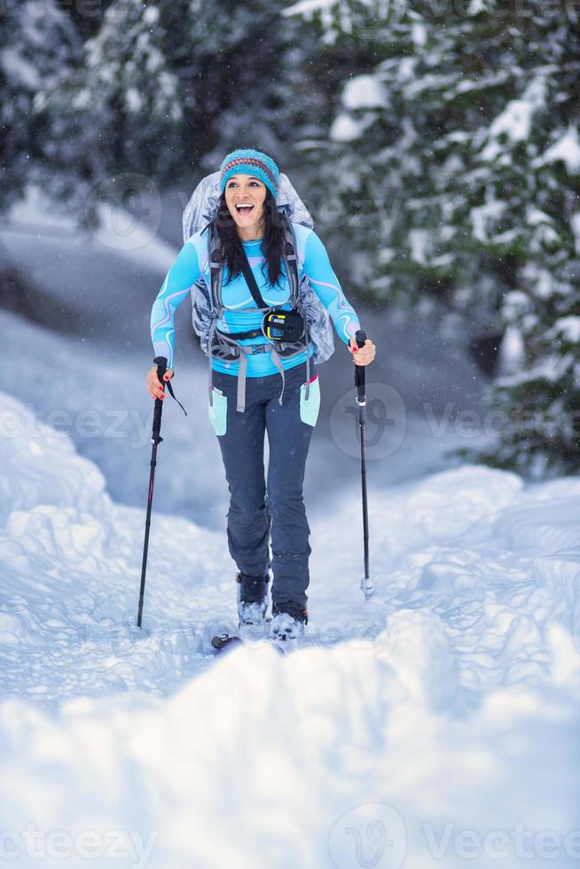 Beautiful young girl practicing ski touring in the woods photo