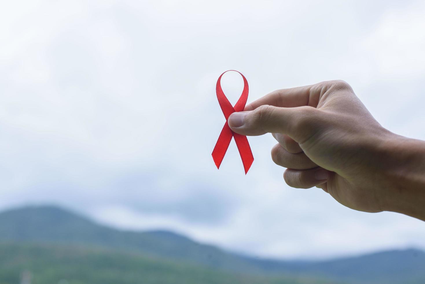 World AIDS day awareness ribbon in female hands photo