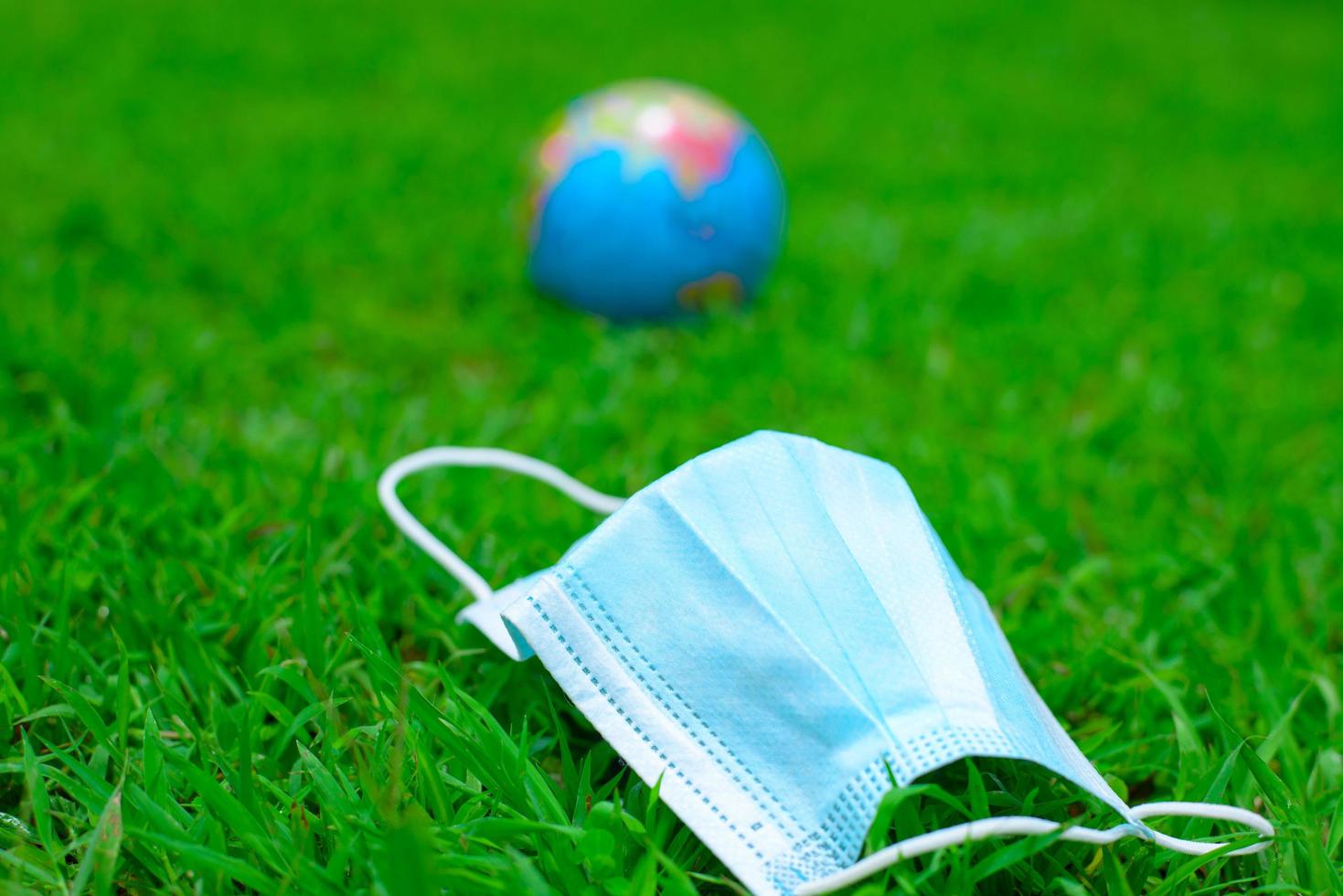 Medical mask in fresh, green spring grass photo