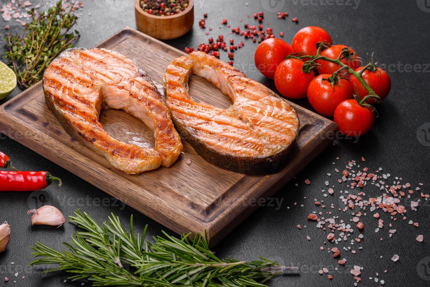 Fresh cooked delicious salmon steak with spices and herbs baked on a grill photo