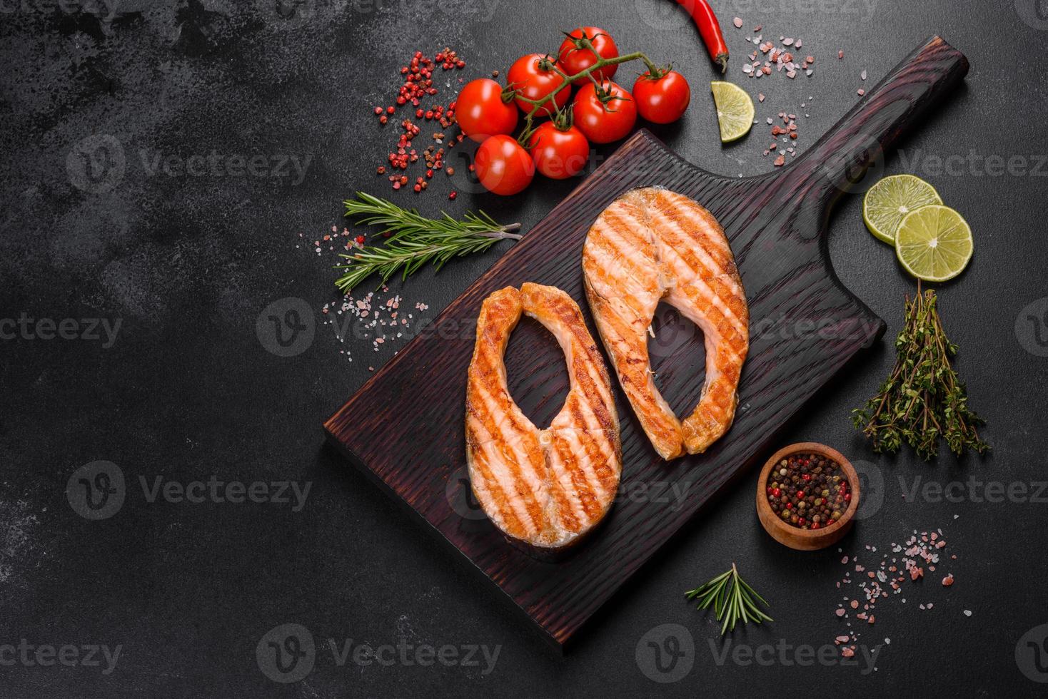 Fresh cooked delicious salmon steak with spices and herbs baked on a grill photo