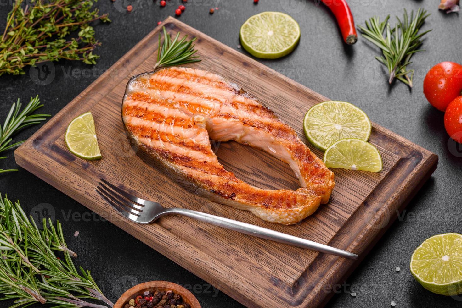 Fresh cooked delicious salmon steak with spices and herbs baked on a grill photo