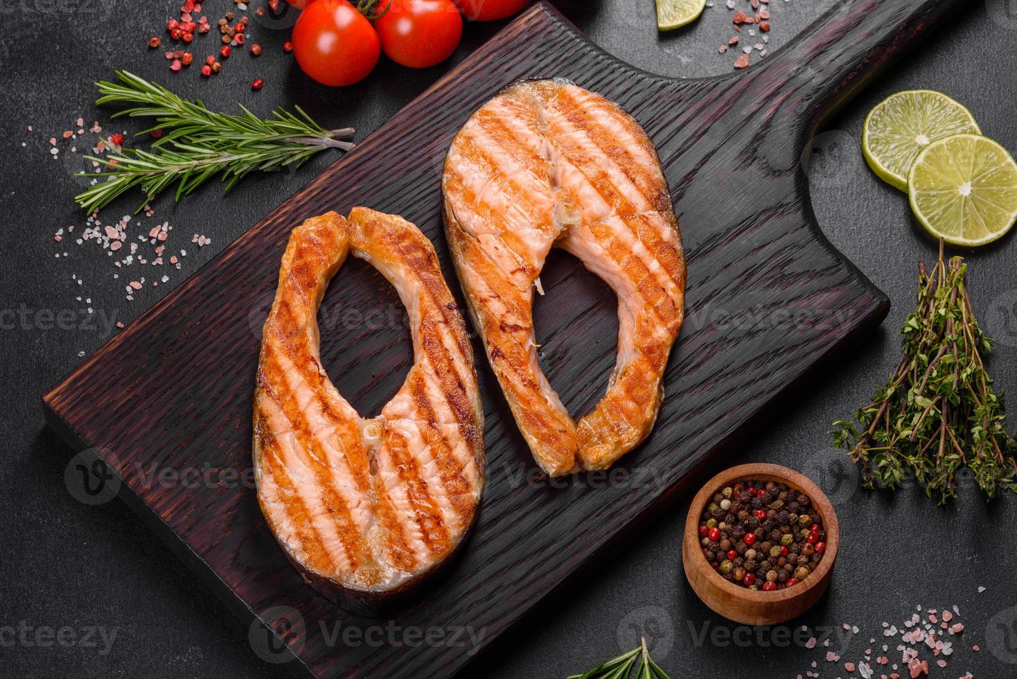 Fresh cooked delicious salmon steak with spices and herbs baked on a grill photo