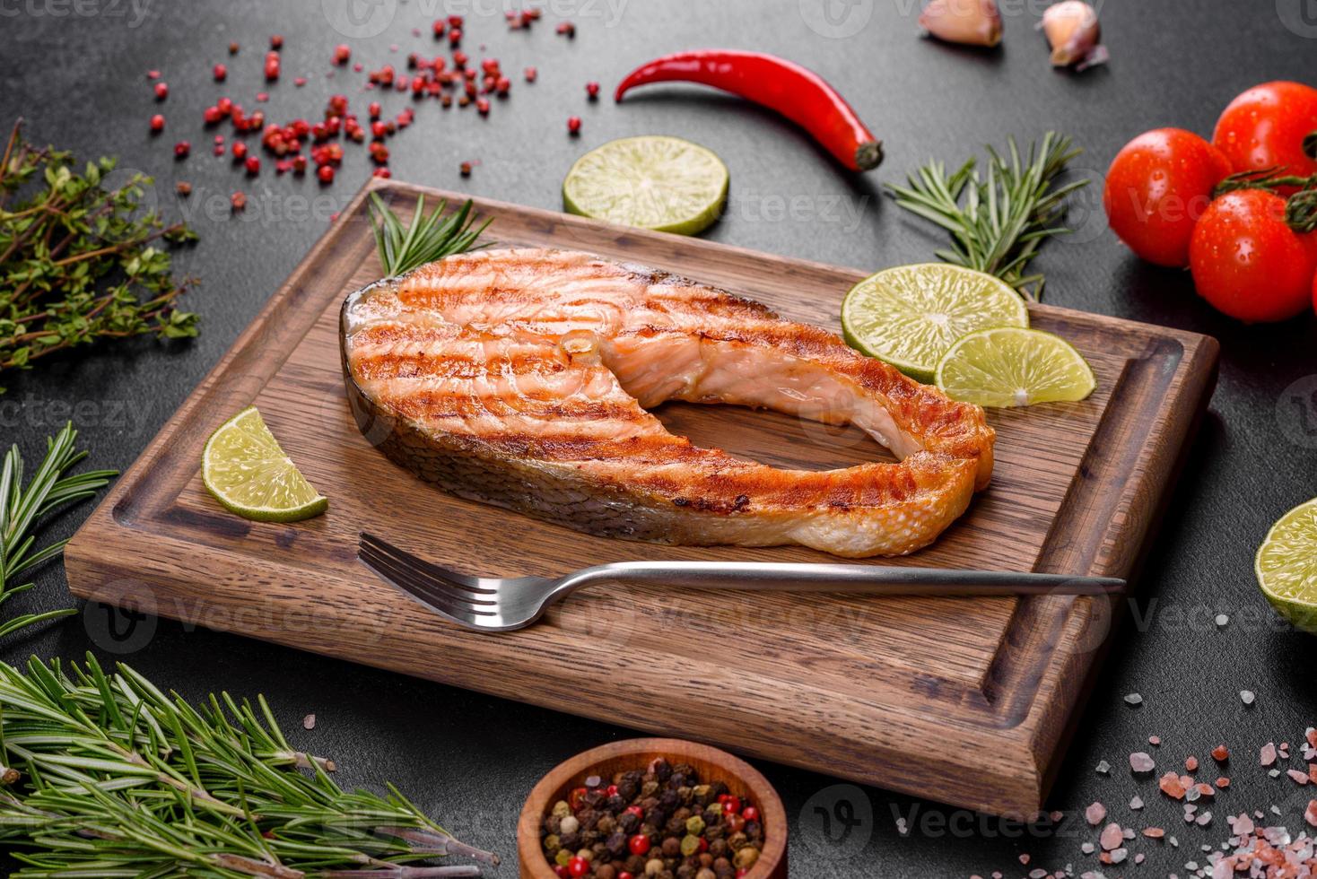 Fresh cooked delicious salmon steak with spices and herbs baked on a grill photo