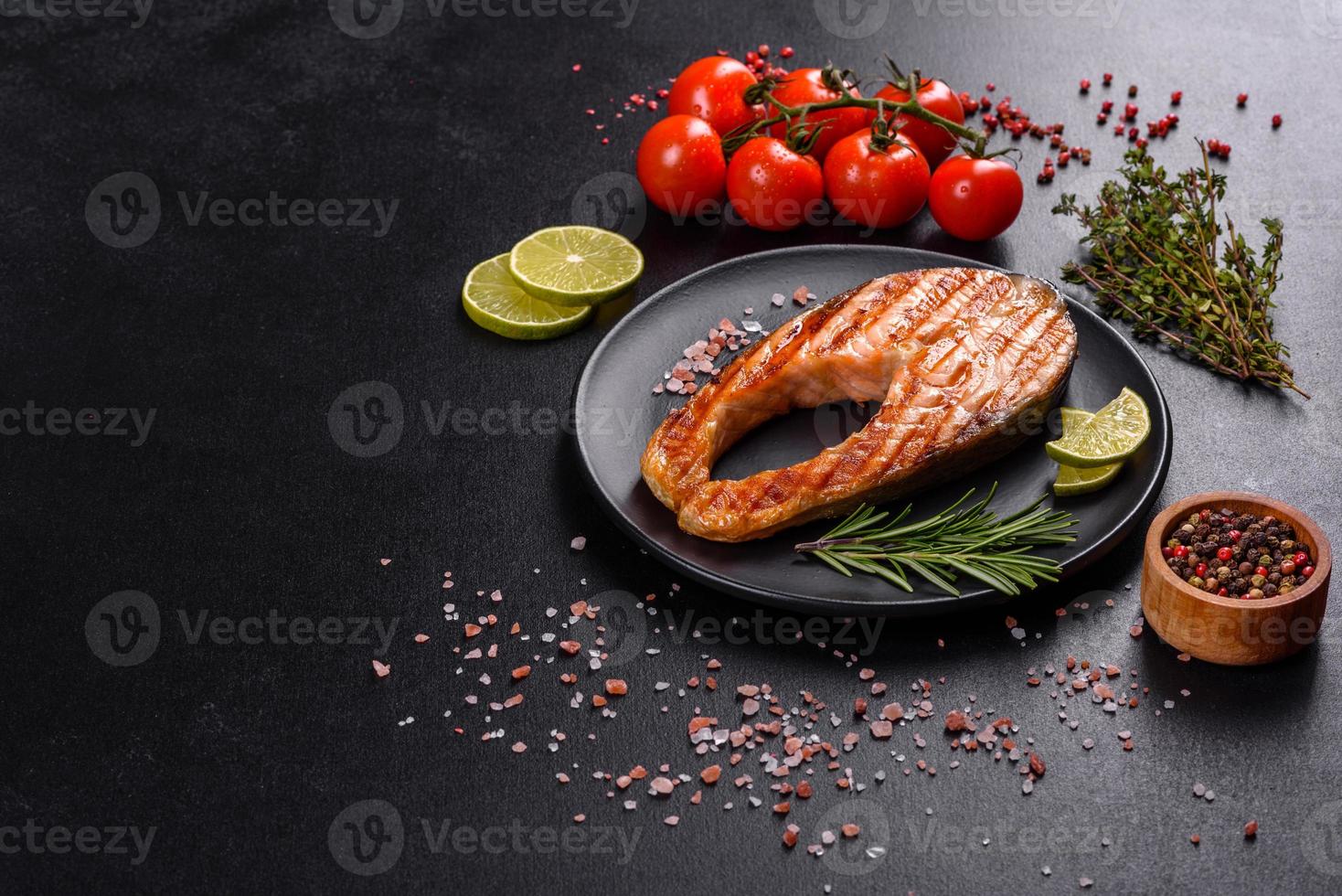 Fresh cooked delicious salmon steak with spices and herbs baked on a grill photo