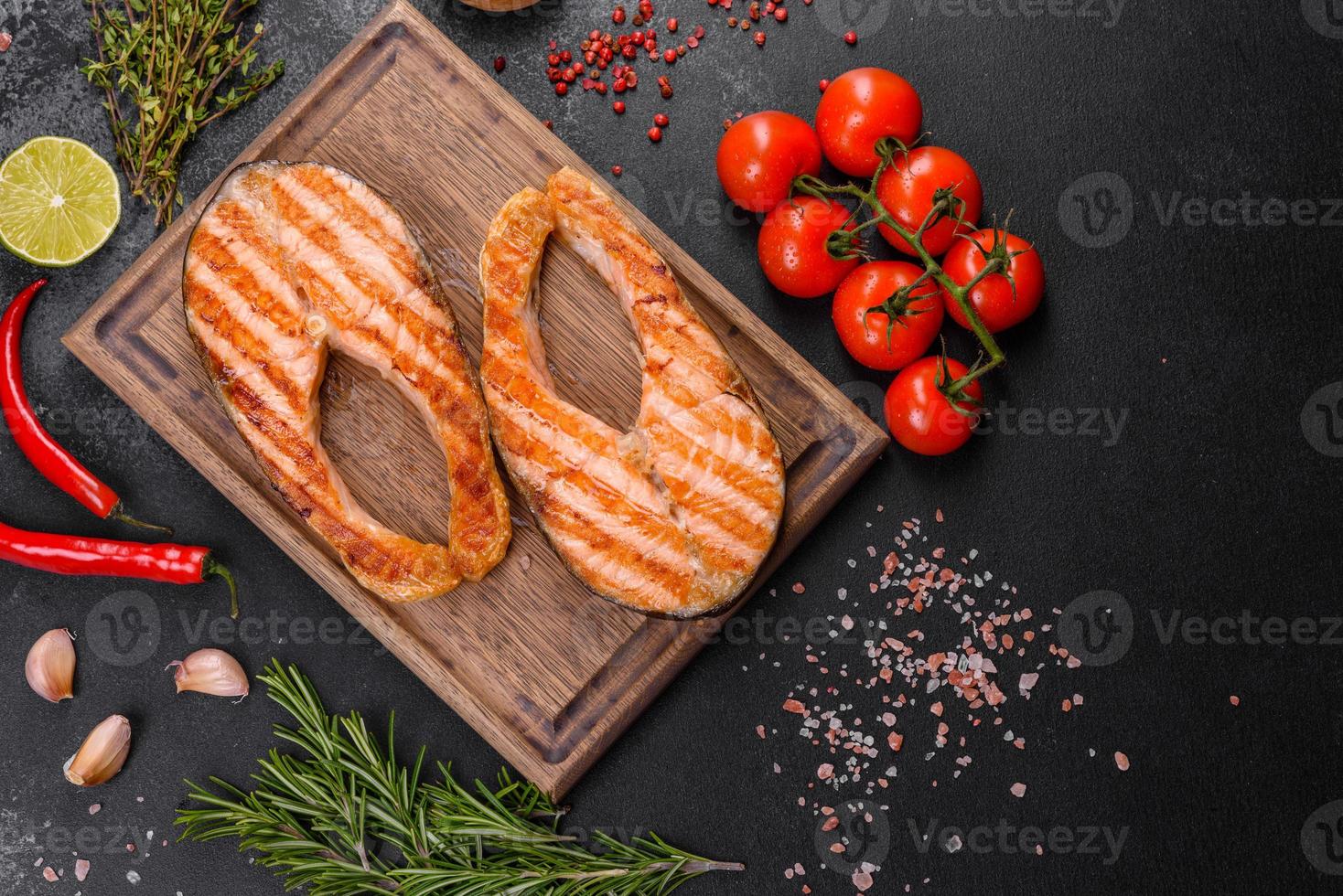 Fresh cooked delicious salmon steak with spices and herbs baked on a grill photo