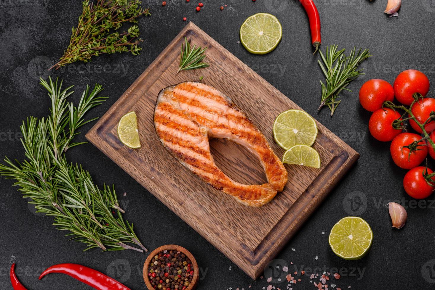 Fresh cooked delicious salmon steak with spices and herbs baked on a grill photo