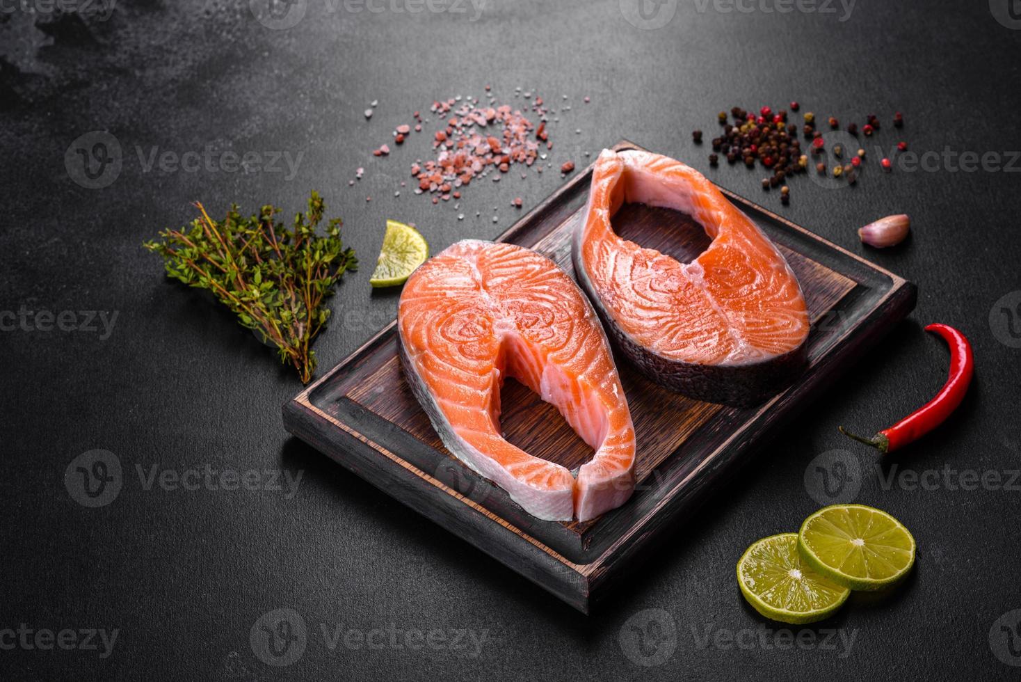 Fresh raw salmon steak with spices and herbs prepared for grilled baking photo