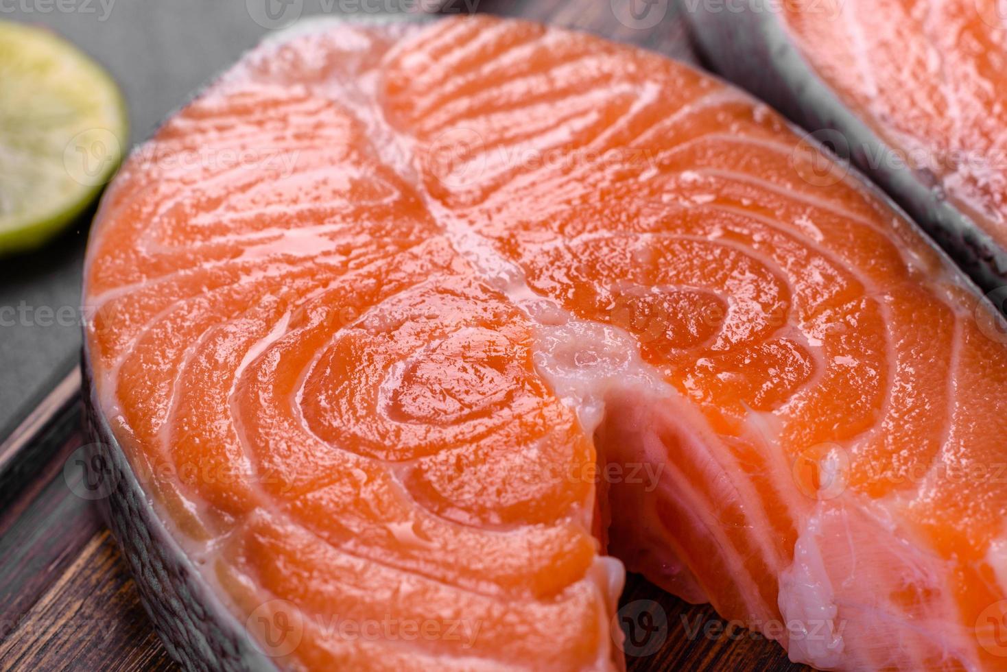 Fresh raw salmon steak with spices and herbs prepared for grilled baking photo