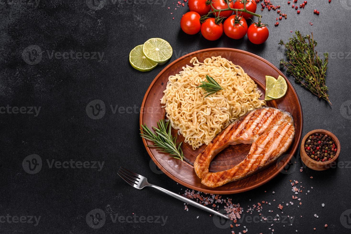 Fresh cooked delicious salmon steak with spices and herbs baked on a grill photo