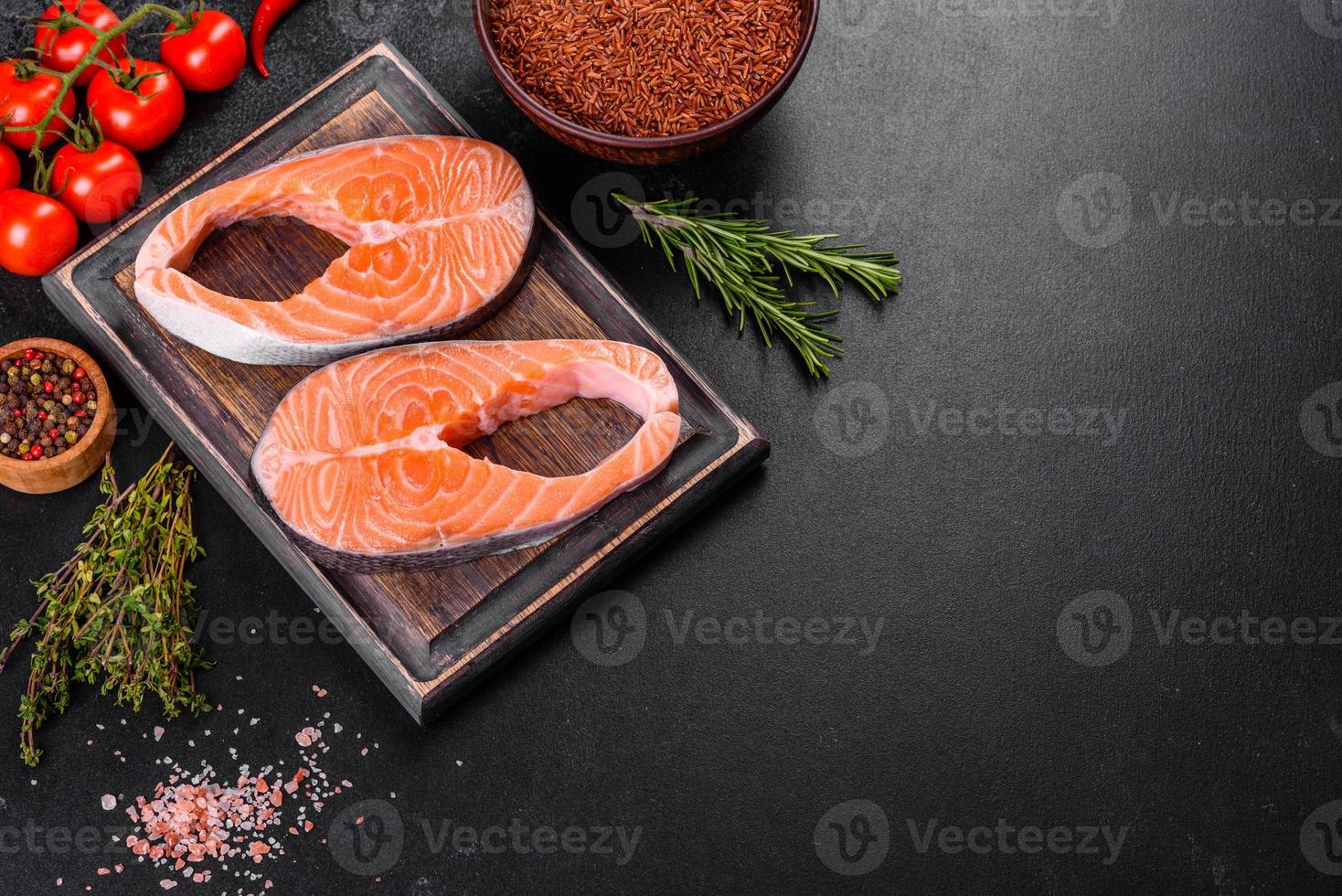 Fresh raw salmon steak with spices and herbs prepared for grilled baking photo