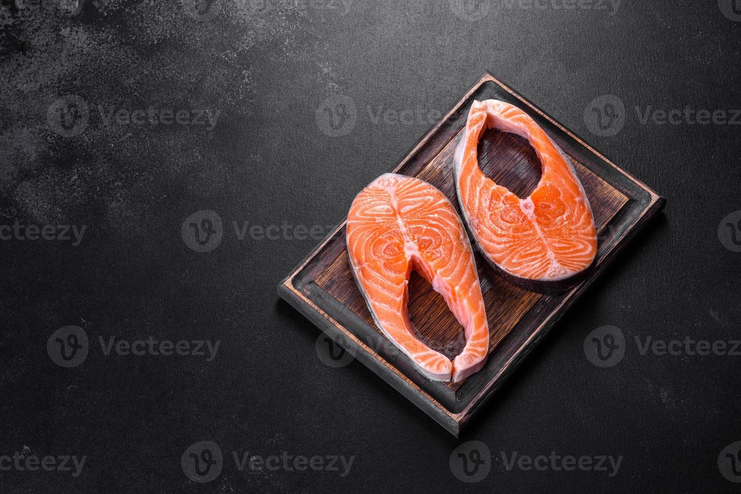 Fresh raw salmon steak with spices and herbs prepared for grilled baking photo