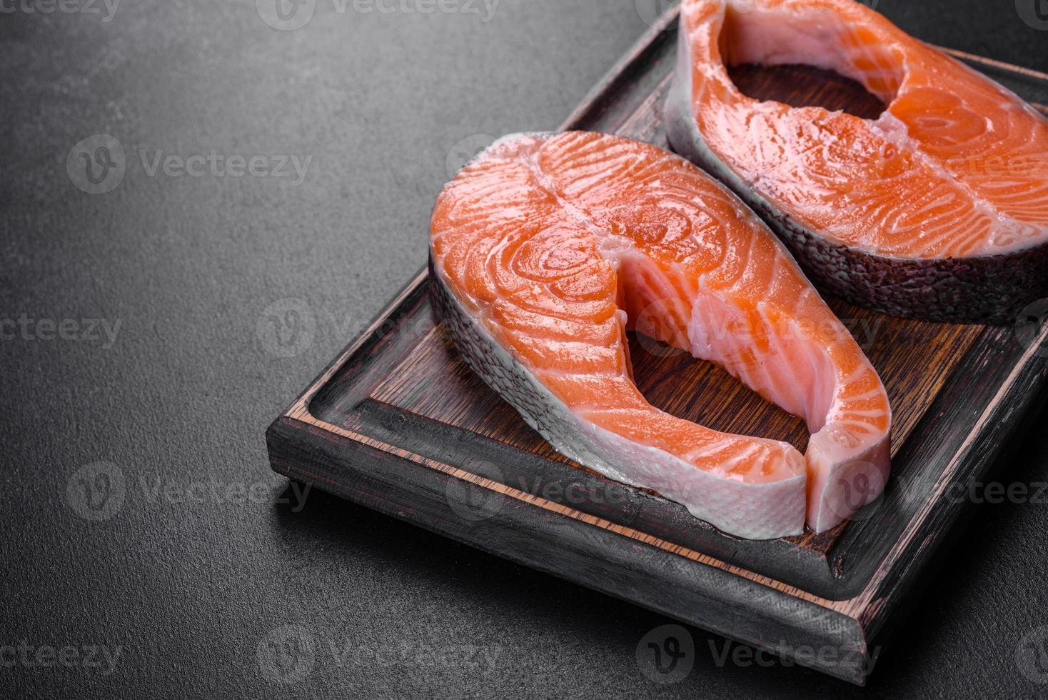 Fresh raw salmon steak with spices and herbs prepared for grilled baking photo