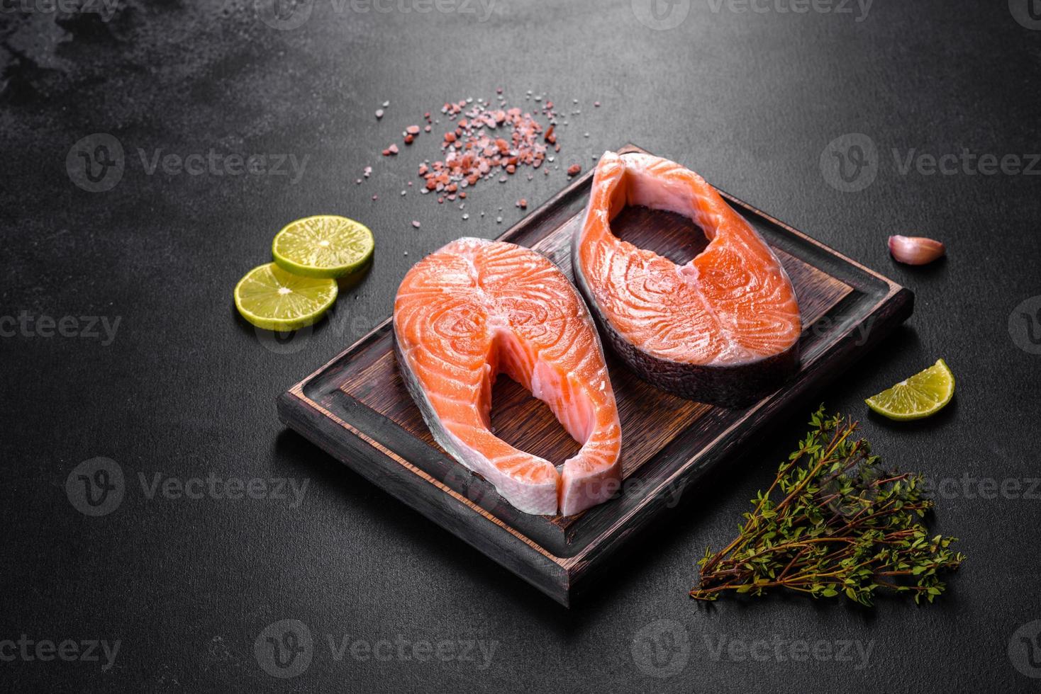 Fresh raw salmon steak with spices and herbs prepared for grilled baking photo