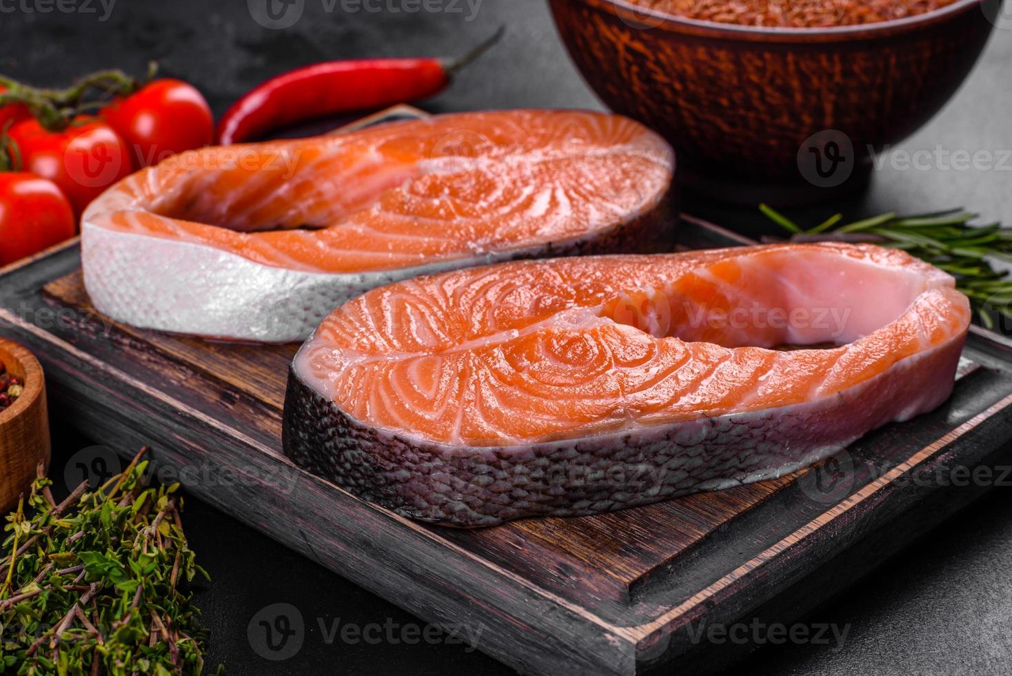 Fresh raw salmon steak with spices and herbs prepared for grilled baking photo