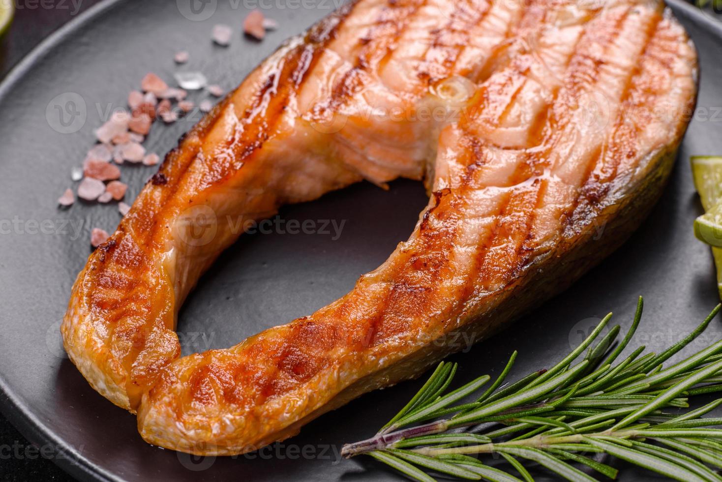 Fresh cooked delicious salmon steak with spices and herbs baked on a grill photo