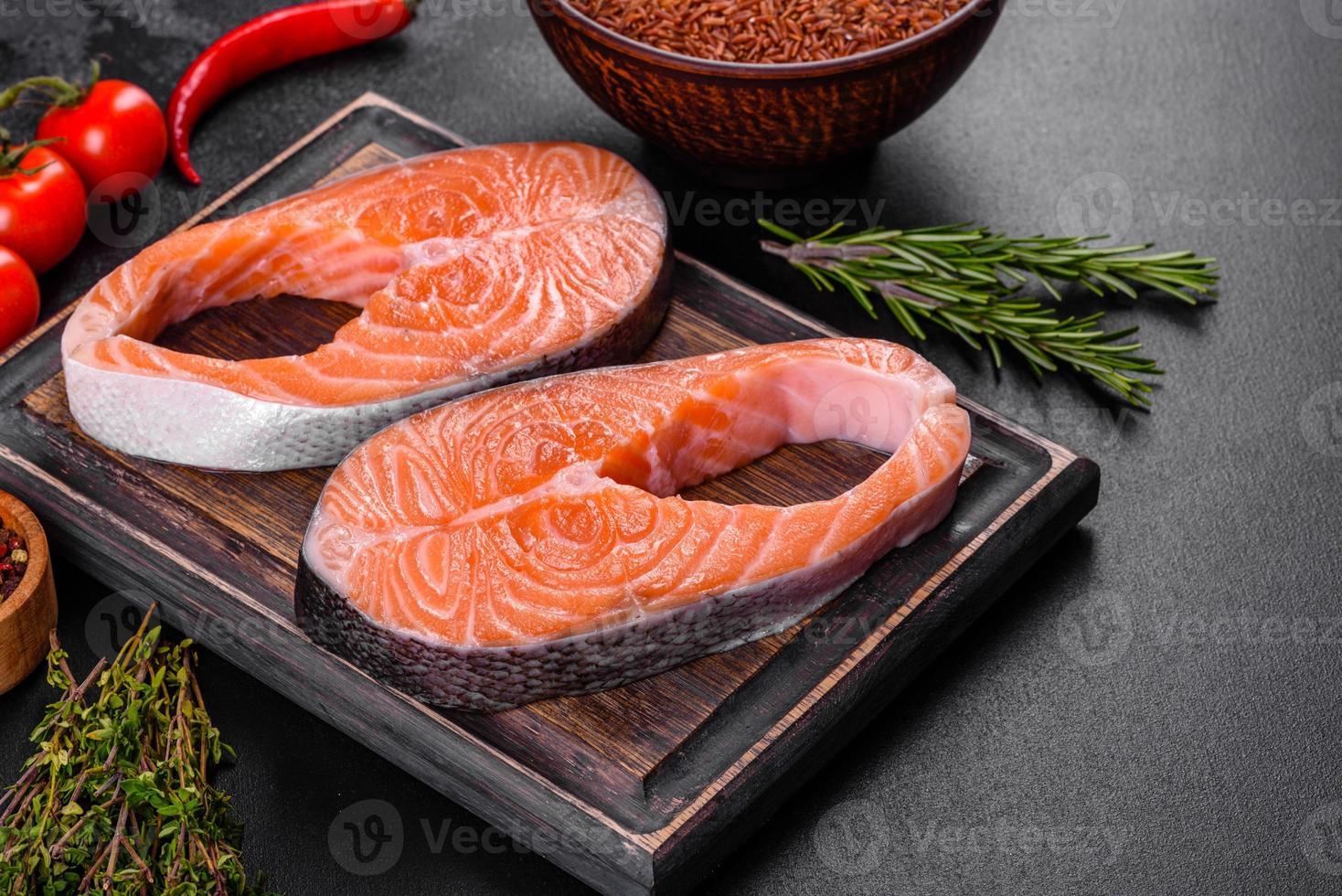 Fresh raw salmon steak with spices and herbs prepared for grilled baking photo