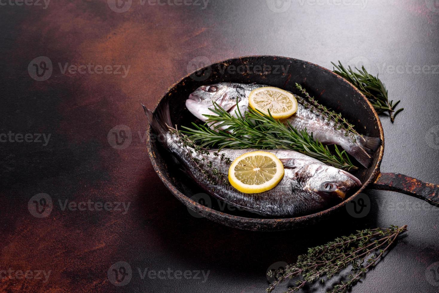 Raw dorado with spices and herbs in a pan is prepared for baking photo