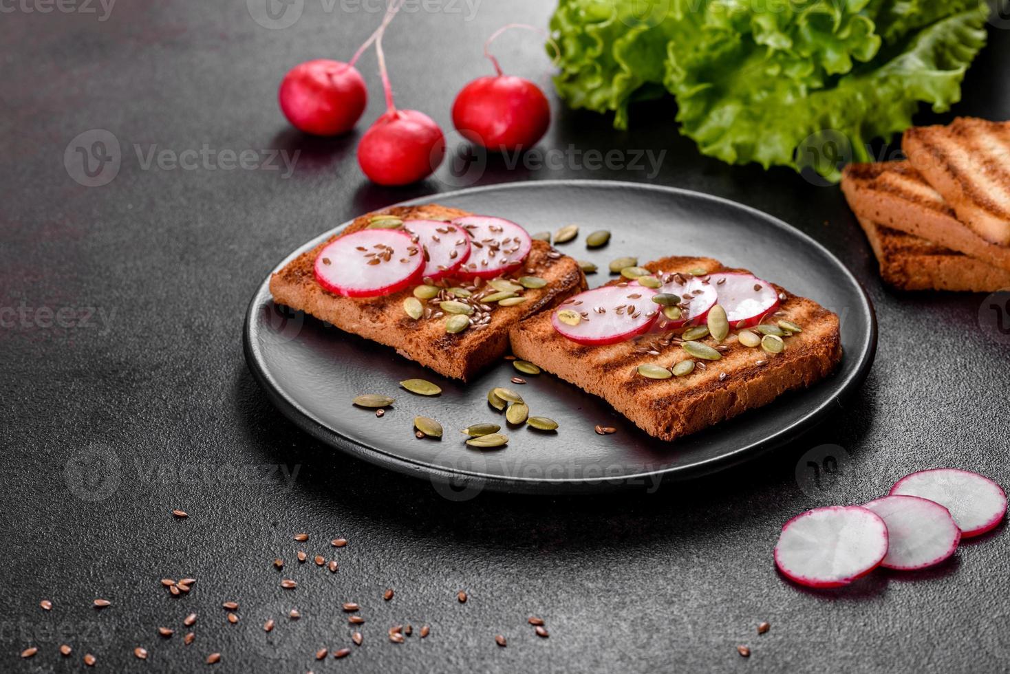 Delicious crisp sandwich with toast, radish, pumpkin seeds and flax seeds photo