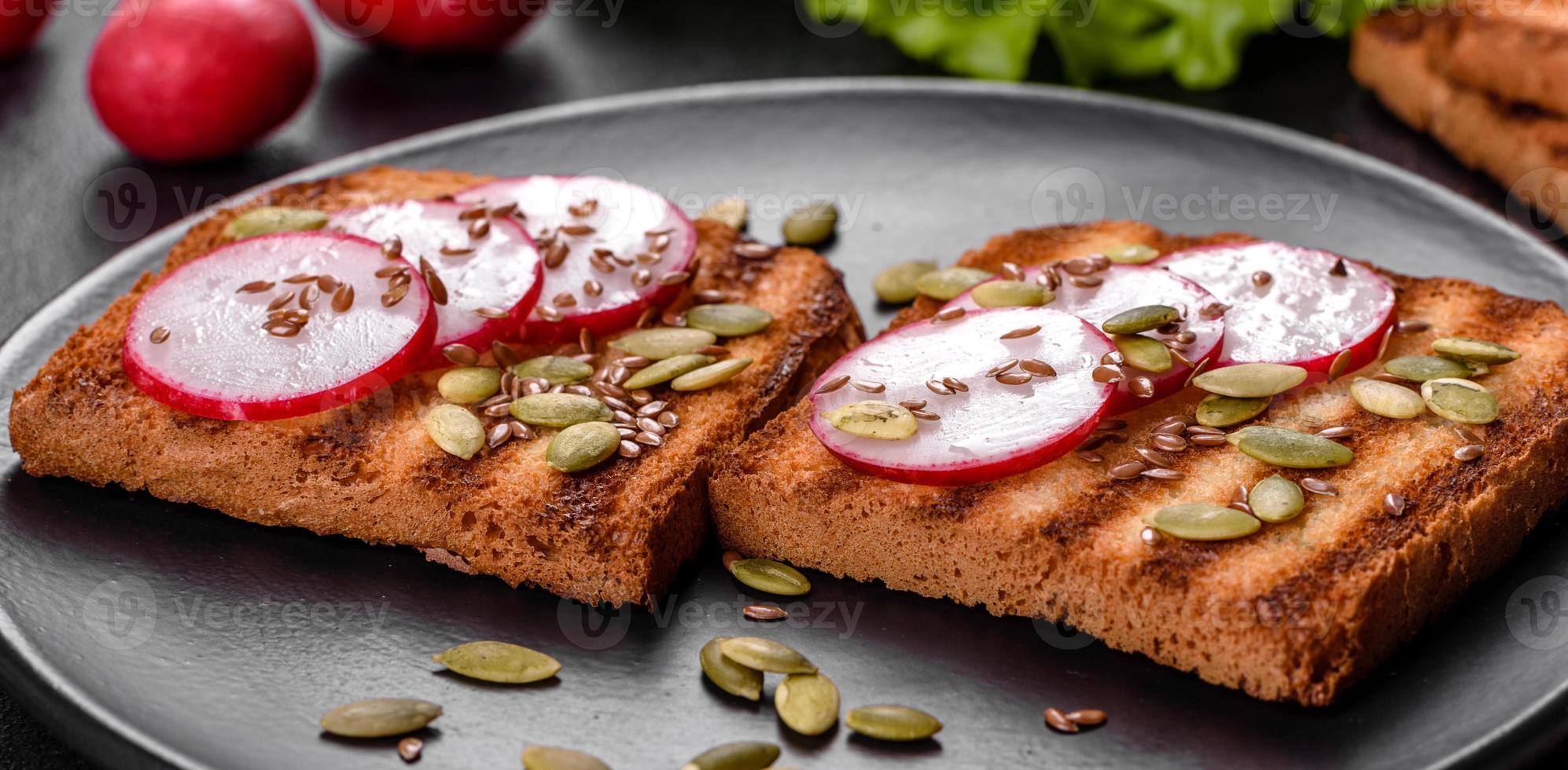 Delicious crisp sandwich with toast, radish, pumpkin seeds and flax seeds photo