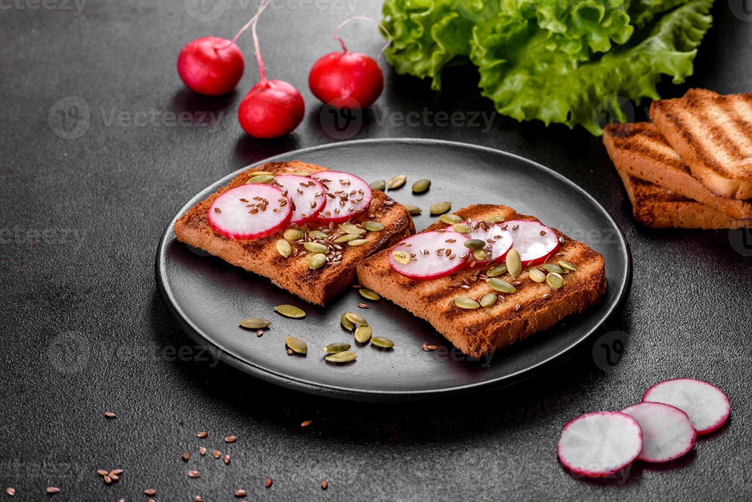 Delicious crisp sandwich with toast, radish, pumpkin seeds and flax seeds photo