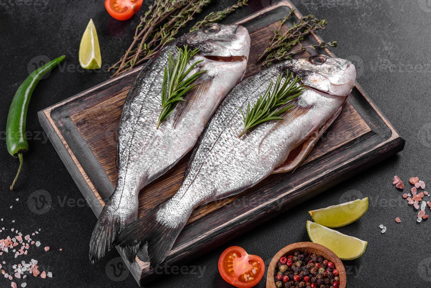 Raw dorado fish with spices cooking on cutting board. Fresh fish dorado photo