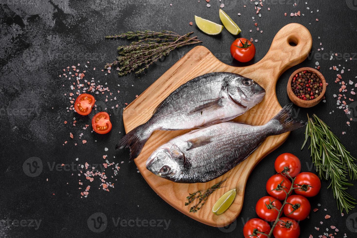 Pescado dorado crudo con especias para cocinar en la tabla de cortar. dorado de pescado fresco foto