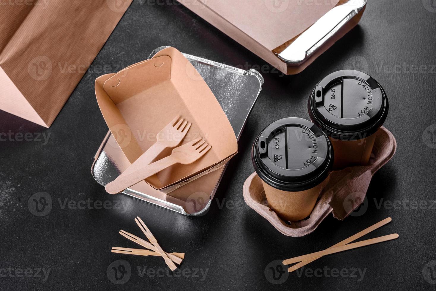 Disposable dishes made of environmentally friendly brown cardboard on a dark background photo