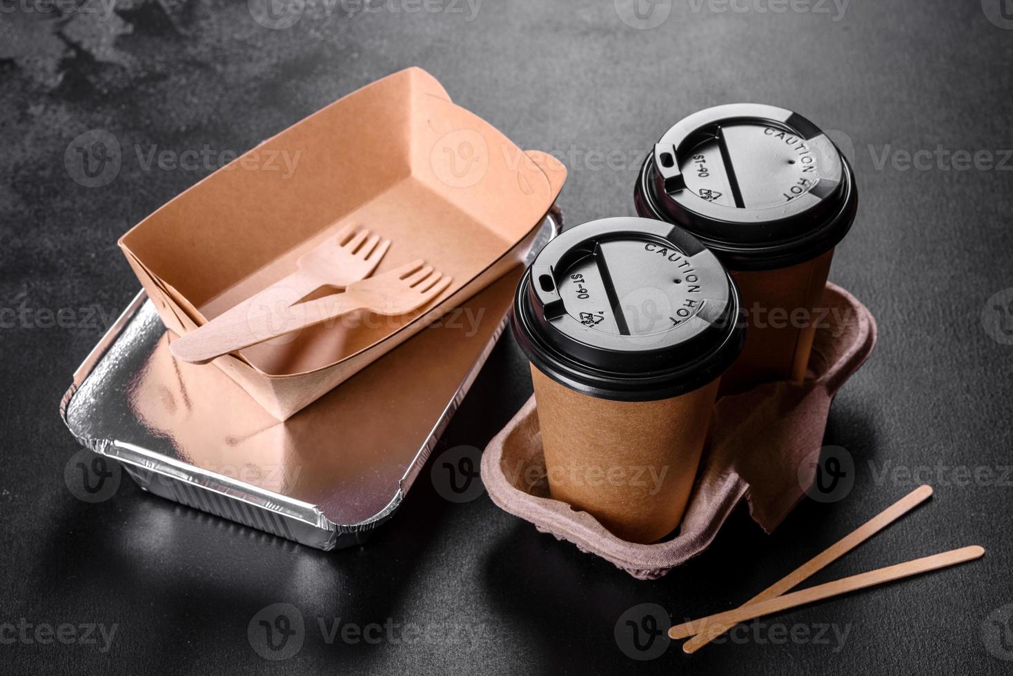 Disposable dishes made of environmentally friendly brown cardboard on a dark background photo